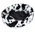 Round pet bed with black and white cow pattern and black inner cushion. Visible logo: Trixie.