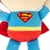 Plyslegetøj i Superman-design med blå dragt, rød kappe og gul bælte. Rødt Superman-logo synligt på bagsiden.