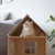 Wooden house for pets with window design, cat sitting inside the house.