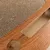 Close-up view of a scratching board made of corrugated cardboard with a wood-look frame and cut-outs.