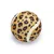 Spielball mit Leopardenmuster, beige Hintergrund mit schwarzen und orangefarbenen Flecken, weiße Streifen entlang der Oberfläche.