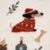 Primo piano di un motivo tessile con cane in maglione rosso, ossi, pallina di Natale e rametti decorativi. Primo piano di un motivo tessile con cane in maglione rosso, ossi, pallina di Natale e rametti decorativi.