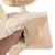 Removable beige padding with hook-and-loop fastener on a wooden cat tree platform. Hand lifts the padding.