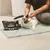 kooa Hygienic Care Wipes, Packung mit 50 Tüchern. Frau reinigt die Ohren einer Katze auf einem grünen Teppich.
