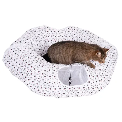 Braune Katze liegt auf einem weissen, bedruckten Katzentunnel mit Spielzeugöffnung und hängendem schwarz-weissem Spielzeug.