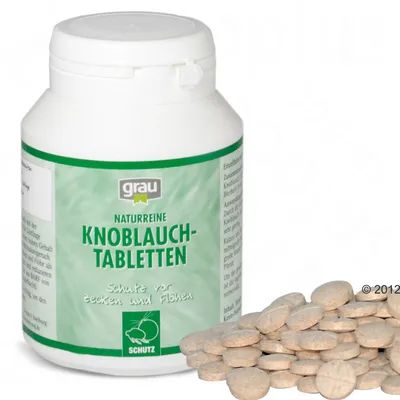 Plastová dóza s nápisem grau Naturreine Knoblauch-Tabletten, Schutz vor Zecken und Flöhen, vedle ní hromádka kulatých tablet.