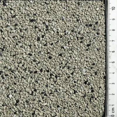 Vue rapprochée de granulés gris avec règle indiquant la taille des grains, échelle en centimètres de 0 à 10 cm visible sur le côté droit de l’image.