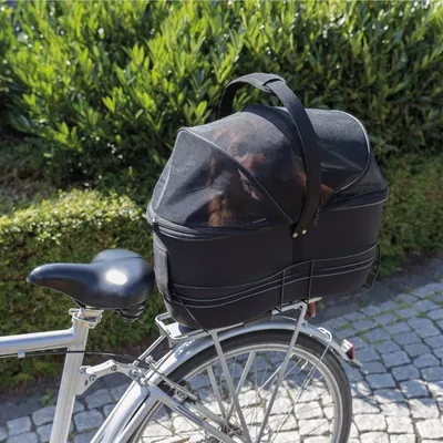Schwarze Fahrrad-Tiertransporttasche mit Netzabdeckung, befestigt am Gepäckträger eines Fahrrads. Geeignet für kleine Tiere, sichtbar durch die Netzabdeckung.