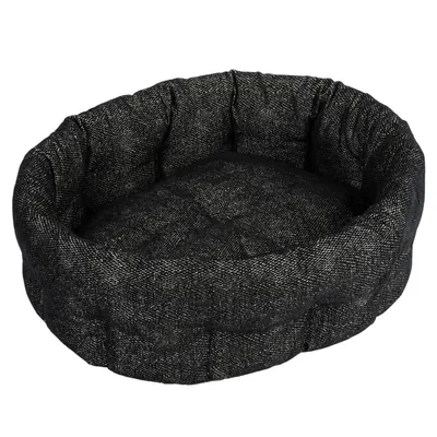 Letto per animali nero, ovale, con bordo imbottito e superficie di riposo morbida in tessuto.