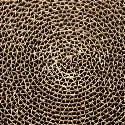 Vue rapprochée d’un carton ondulé en spirale, matériau visible utilisé pour griffoirs ou jouets pour chats.