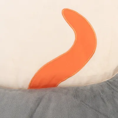 Yksityiskohtainen näkymä oranssista kangaselementistä kermanvärisellä ja harmaalla taustalla, mahdollisesti osa lemmikkituotetta.