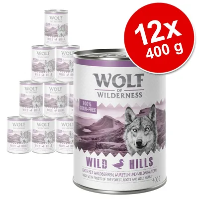 Pack de 12 latas de 400 g Wolf of Wilderness Wild Hills, 100% grain-free. Texto visible: 'Ente mit Waldbeeren, Wurzeln und Wildkräutern. Duck with fruits of the forest, roots and wild herbs'. Pack de 12 latas de 400 g Wolf of Wilderness Wild Hills, 100% grain-free. Texto visible: 'Ente mit Waldbeeren, Wurzeln und Wildkräutern. Duck with fruits of the forest, roots and wild herbs'.
