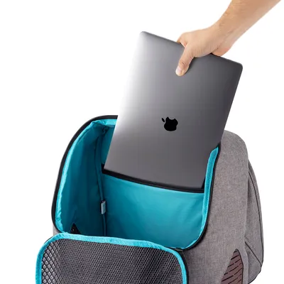 Harmaa reppu turkoosilla vuorauksella, sopii kannettaville tietokoneille. Käsi asettaa Apple-logolla varustetun kannettavan pehmustettuun lokeroon.