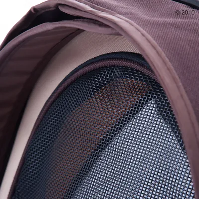 Крупный план сетчатого окна из чёрного пластика на коричневой переноске для животных из ткани.