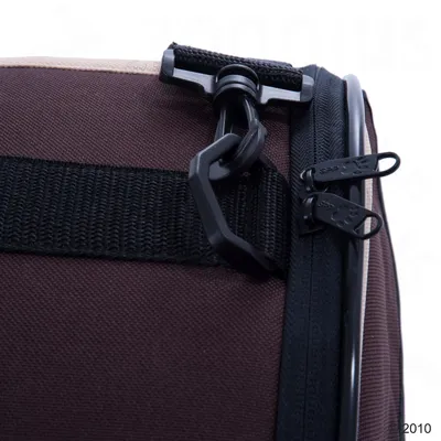 Крупный план пластикового карабина и двух собачек на молнии на коричневой текстильной сумке или переноске для животных