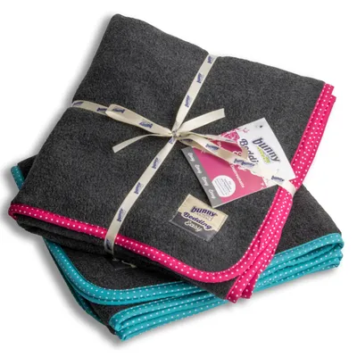 Bunny Bedding Easy, pătură gri cu margine roz și turcoaz, cu buline. Ambalată cu bandă Bunny și etichetă.