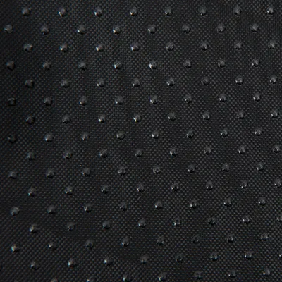 Nahaufnahme eines schwarzen, rutschfesten Materials mit kleinen Noppen für besseren Halt.