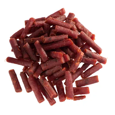 Bouchées en forme de bâtonnets rouges, sans emballage ni marque visible, présentées en tas sur fond blanc.
