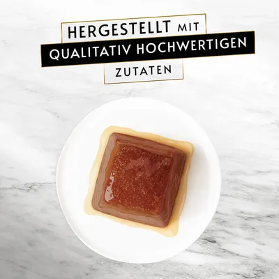 Hergestellt mit qualitativ hochwertigen Zutaten. Gezeigte Portion in quadratischer Form auf weissem Teller.