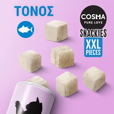 COSMA PURE LOVE SNACKIES XXL PIECES, ΤΟΝΟΣ. Κύβοι λιχουδιάς με τόνο και συσκευασία με γάτα σε ροζ φόντο. Ορατό σύμβολο τόνου.