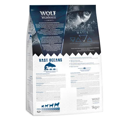 Wolf of Wilderness Elements Vast Oceans, confezione da 1 kg. Testo in inglese e tedesco, simboli di pesce e cane, tabella peso cani visibile. Nessun conservante artificiale, made in Germany.