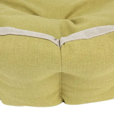 Nærbillede af hjørne på rektangulær hundeseng i lysegrønt tekstil med lys kant. Synlige syninger og polstring.