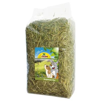 JR Farm siano z górskich łąk w przezroczystym opakowaniu, z ilustracją królika i świnki morskiej na zielonym polu. Tekst: „Frisch vom Land”.