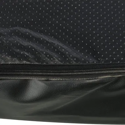 Nahaufnahme eines schwarzen, gepunkteten Stoffes mit Reissverschluss und Kunstledermaterial. Detailansicht der Materialien eines Produkts.