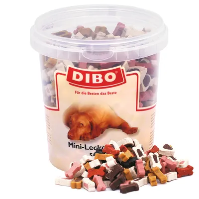 Secchiello trasparente con marchio DIBO, testo tedesco 'Für die Besten das Beste', immagine di cane e scritta 'Mini-Leckerli 500 g'. Snack a forma di osso visibili in vari colori.