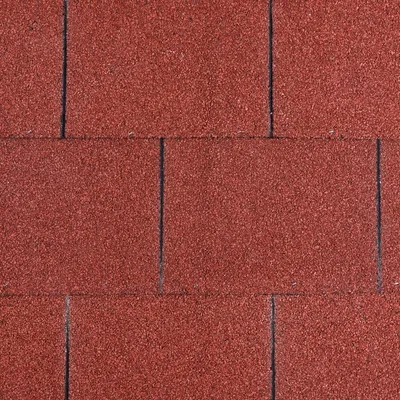 Vue rapprochée de tuiles ou bardeaux rouges, surface granuleuse, disposition en rangées régulières. Aucun texte ni marque visible.