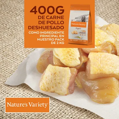 Nature's Variety Original. 400G DE CARNE DE POLLO DESHUESADO COMO INGREDIENTE PRINCIPAL EN NUESTRO PACK DE 2 KG (текст на испанском). Кусочки куриного филе и упаковка корма.