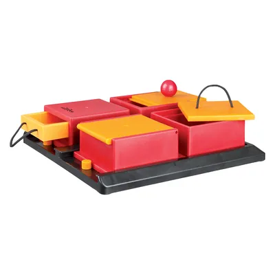 Rød og gul aktivitetsbræt i plastik med skuffer, låg og snoretræk på sort bundplade. En rød bold ligger ovenpå et af lågene. Ingen synlig tekst eller mærke.
