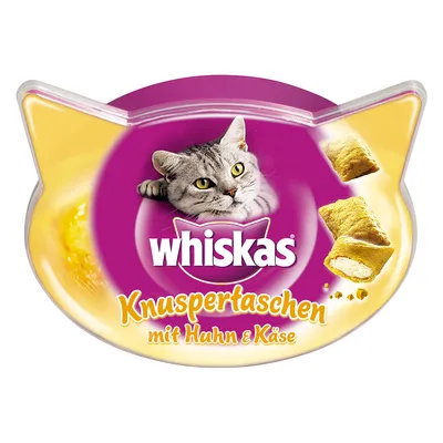 Whiskas Knuspertaschen mit Huhn & Käse -kissanherkkupakkaus, näkyvissä täytettyjä herkkupaloja ja harmaa kissa. Pakkausmuoto kissanpään mallinen.