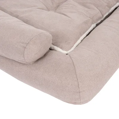 Coussin rectangulaire pour animal, tissu beige avec rebords rembourrés et intérieur bordé de fausse fourrure blanche visible sur le côté.