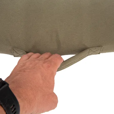 Nahaufnahme einer Hand, die einen stabilen Tragegriff aus Stoff an einem olivgrünen Produkt hält.