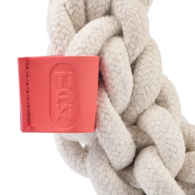 Geflochtenes Seilspielzeug aus cremefarbenem Baumwollmaterial mit rotem Tiaki-Logoetikett.