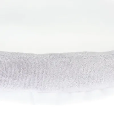 Bord d’un coussin ou panier pour animal en tissu gris clair et blanc, surface douce visible. Aucun logo ni texte apparent.
