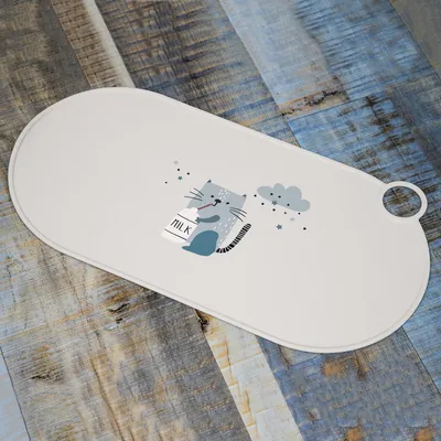 Set de table ovale en plastique avec illustration d’un chat tenant une bouteille marquée « MILK » et un nuage décoratif. Trou rond pour suspension visible sur le côté.