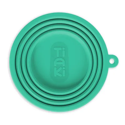 Tiaki collapsible bowl made of green silicone with practical hanging hole, ideal for travel.