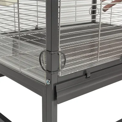 Detailansicht eines Käfigs mit Metall-Gitterwänden und Plexiglas-Elementen, inklusive stabiler Verschlüsse und einer herausziehbaren Bodenwanne.