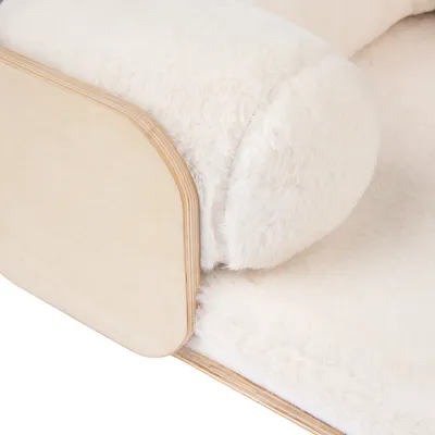 Detailansicht eines Möbelstücks mit hellem Holzrahmen und weicher, weisser Plüschpolsterung.