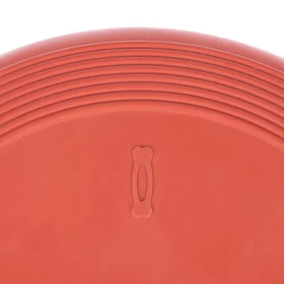 Rød frisbee af plast med præget benmotiv i midten og rillet kant.