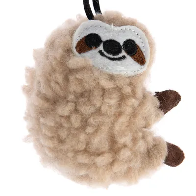 Giocattolo a forma di bradipo in peluche beige con dettagli in feltro marrone e passante nero per appendere.