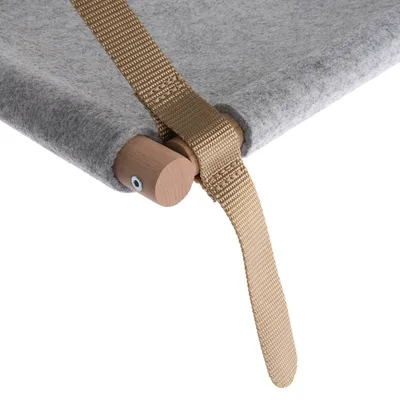 Detaljvy av en grå tygyta med trästav och beige rem, fäst med en skruv.