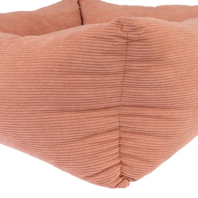 Bližnji posnetek oranžnega, rebrastega tekstilnega materiala pravokotne blazine za posteljo.