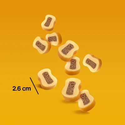 Velikost prigrizka: 2,6 cm. Rumeno-rjavi prigrizki z mehkim polnilom, primerni za natančno odmerjanje porcij.