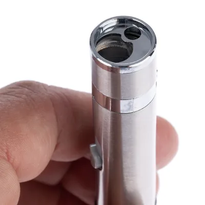 Close-up of a silver laser pointer with metal casing, held by a hand. The lens and a switch on the casing are visible.