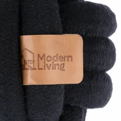 Modern Living. Zwarte stof met bruin leren label en ingedrukt logo.
