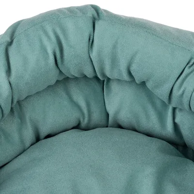 Close-up van een gevoerd, groen stoffen bed met een zacht oppervlak.