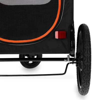 Detaljvy av en svart cykelvagn med orange kant, reflex och däckmönster.